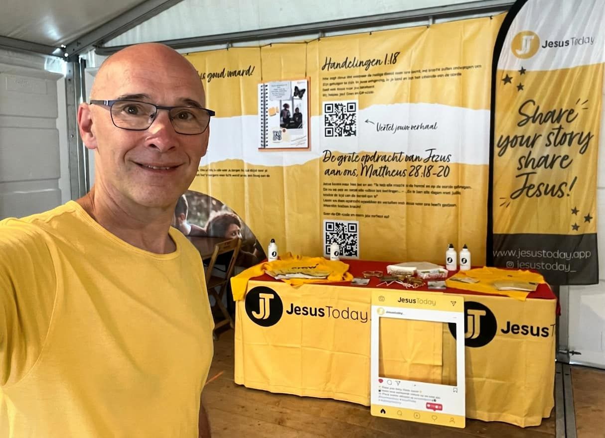 JesusToday stand op een event met QR-kaartjes, banner en merchandise